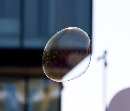 Beautiful soap bubbles fly in the city .