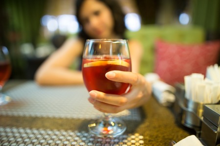 A girl drinks a red strawberry drink in a restaurant .の写真素材