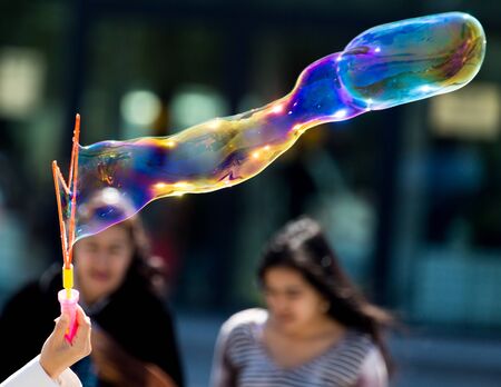 Beautiful soap bubbles fly in the city .