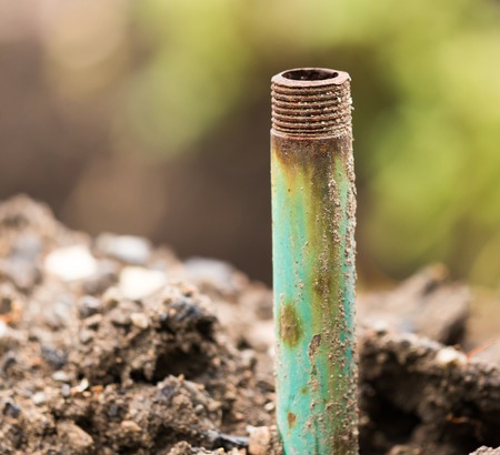 Rusty metal pipe in the ground for water .の写真素材