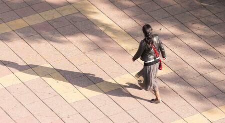 The girl is walking along paving stones .