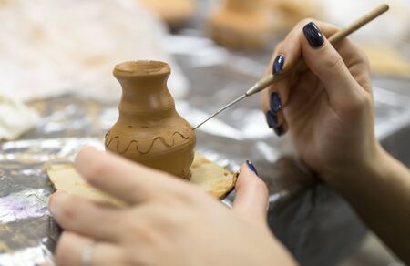 The master makes by hands the product of dishes from clay