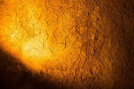 Clay wall in golden light as background .