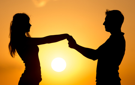 Silhouette of a guy and a girl at sunset .の写真素材