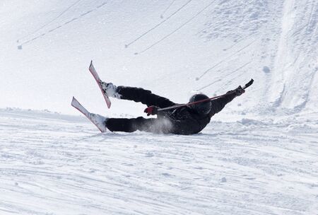 The skier fell in the snow at speed .