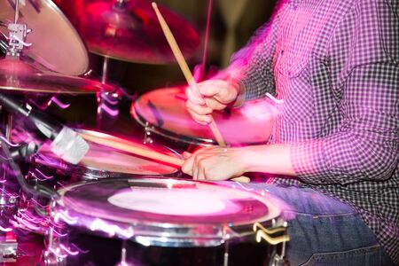 Musician plays drums in a rock band .