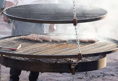 Sausages are fried on a large barbecueの写真素材
