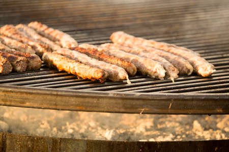 Sausages are fried on a large barbecue
