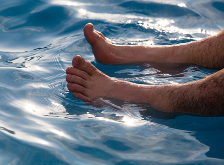 Legs of men near the pool on vacationの写真素材