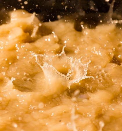 Rain drops fall into a dirty puddle .の写真素材