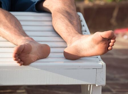 Legs of men near the pool on vacationの写真素材
