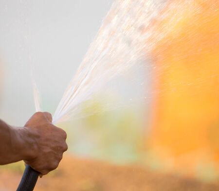 Man watering the lawn with a hose .