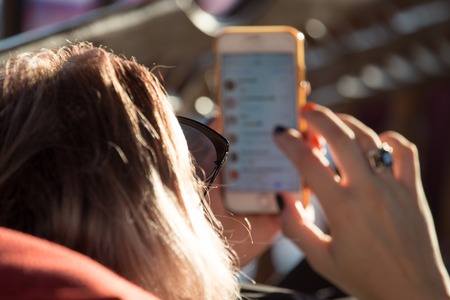 Girl in glasses from the sun with phone .の写真素材