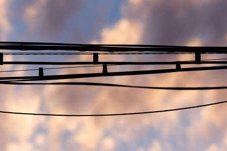 Electric wires at sunset as an abstract backgroundの写真素材