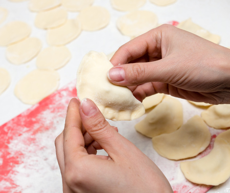 Cook cooks vareniki with potatoes in the kitchenの写真素材