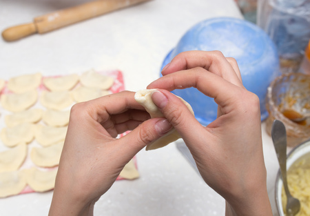 Cook cooks vareniki with potatoes in the kitchenの写真素材