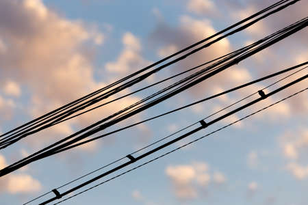 Electric wires at sunset as an abstract backgroundの写真素材