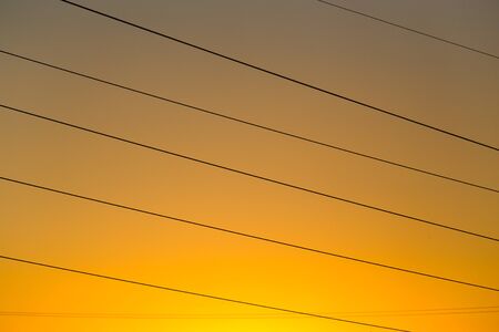 Electric wires on yellow sunset as background .の写真素材