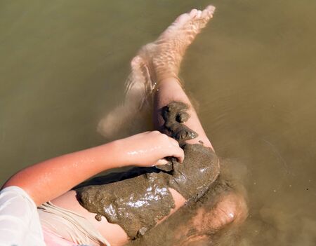 Girl playing in the sand on the lake .の写真素材