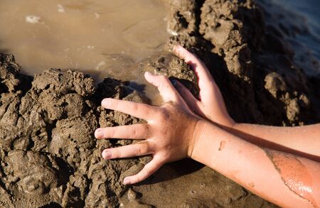 Girl playing in the sand on the lake .