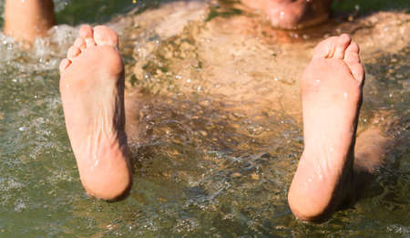 Mens legs on the water in the poolの写真素材
