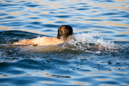The man is swimming in the lakeの写真素材