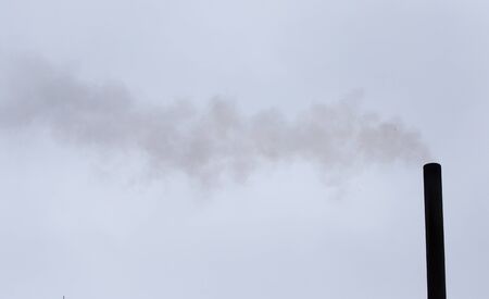 Smoke from a pipe on a cloudy skyの写真素材
