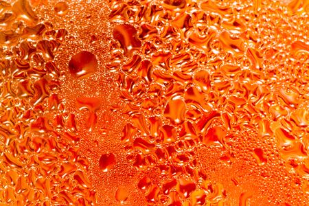 abstract background of drops on a red glassの写真素材