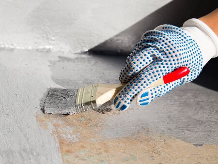 painting with a brush of a metal plate with silver paint
