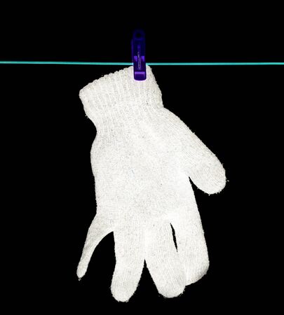 The glove is dried on a rope on a black backgroundの写真素材