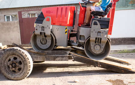 heavy machine rolls a new asphalt road