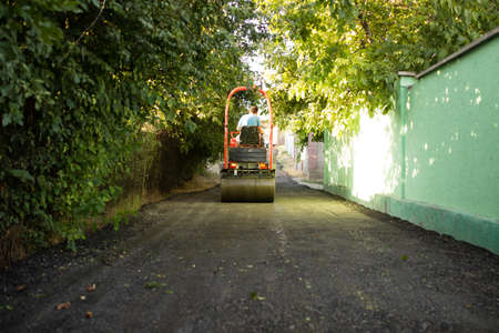 heavy machine rolls a new asphalt road