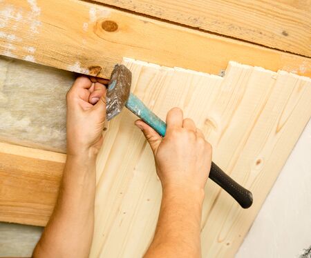 worker working on a wooden ceiling in the house