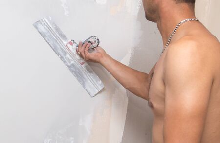 the worker plastered the mortar on the wall .