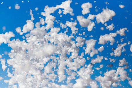 White foam against the blue sky as background .