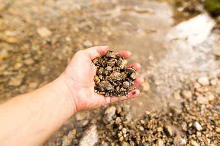 Small stones in the hand on the pond .の写真素材