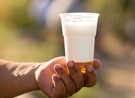 white foam in a glass of beer in hand .の写真素材