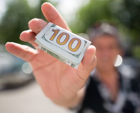 one hundred dollars in a man's hand .の写真素材