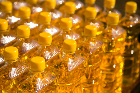 yellow vegetable oil in plastic bottles as background .