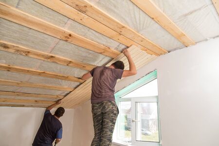 worker working on a wooden ceiling in the house .の写真素材