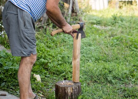 man chopping wood with an ax in the open air .の写真素材