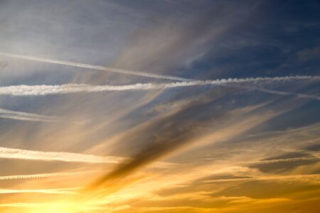 traces of an airplane at sunset as background .