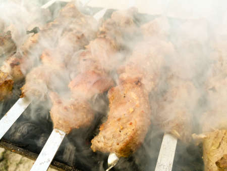 Shish kebab on metal sticks roasted on the grill .の写真素材