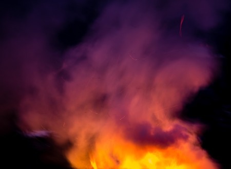 fire with smoke on a black background .