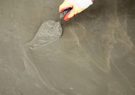 worker pours concrete mortar on a construction site .