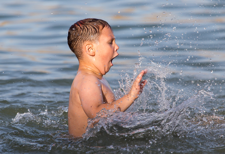 boy is bathed in the lake to the beachの写真素材