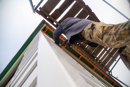 Workers walling the house with wall sidingの写真素材