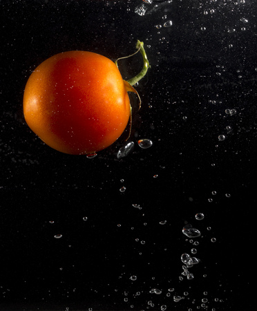 tomato in water on a black background .の写真素材