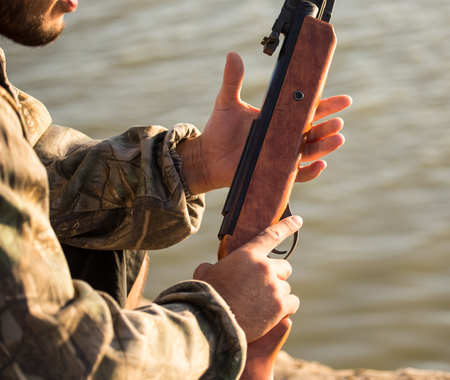 The gun in the hands of the hunter .