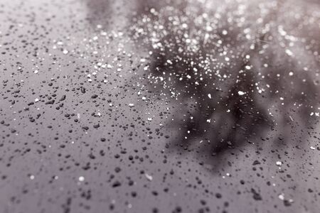 Snowflakes on a black car as a background .